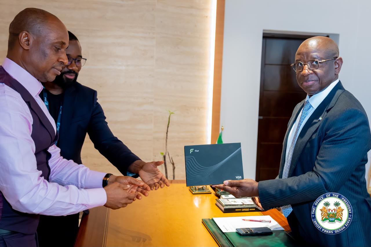 President Bio holds the Flot Visa presentation box at State House.